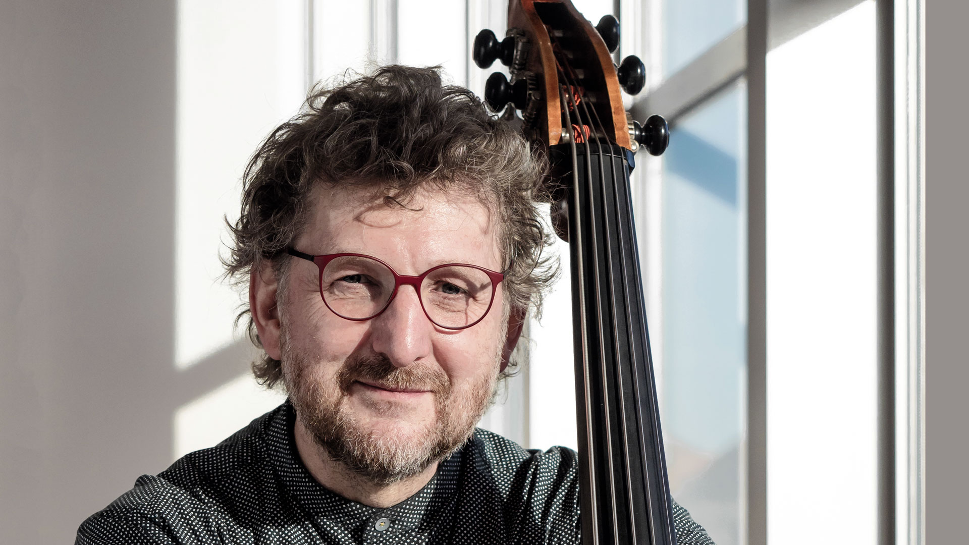 Portraitfoto von Matthias Pagenkopf mit Kontrabass im Foyer des Kulturpalastes Dresden
