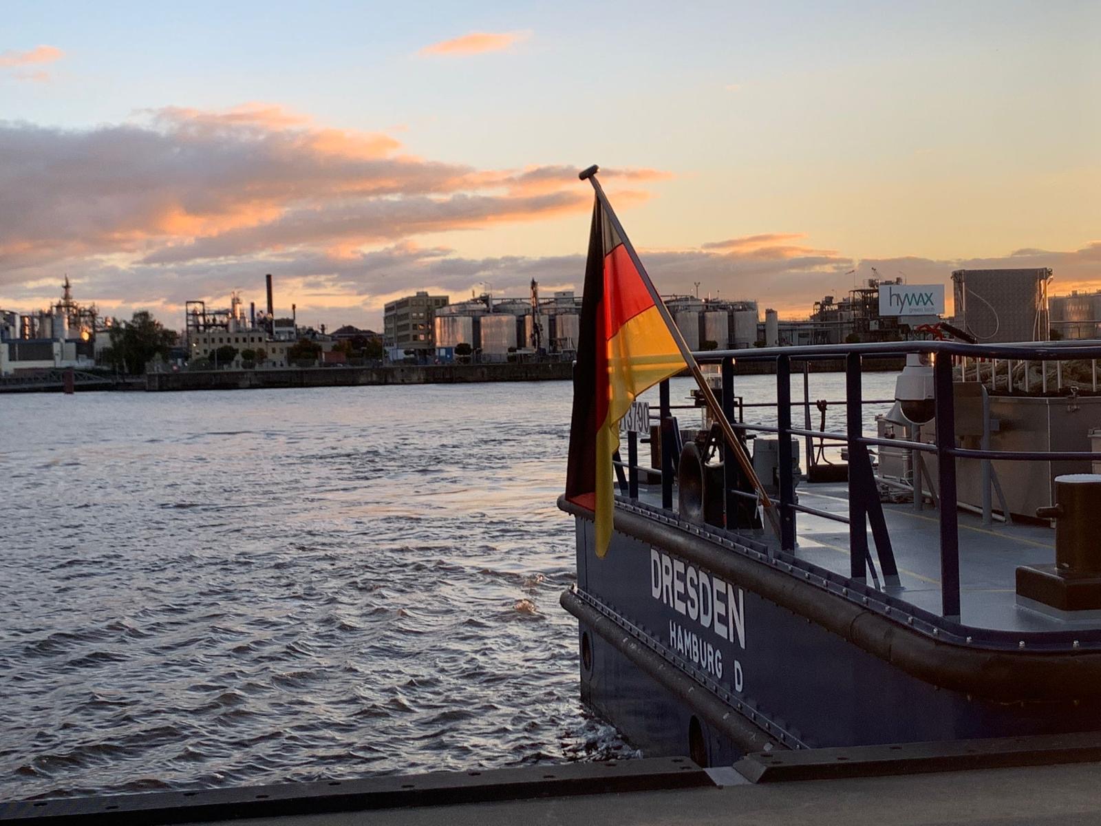 Ein Kahn mit Namen "Dresden" liegt am Kai im Hamburger Hafen, Blick aufs Wasser in der Abendsonne. Foto © Probst