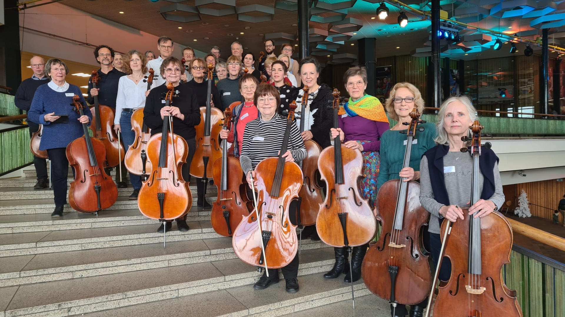 Viele Cellisten stehen mit ihren Instrumenten auf der Treppe des FEZ aufgereiht