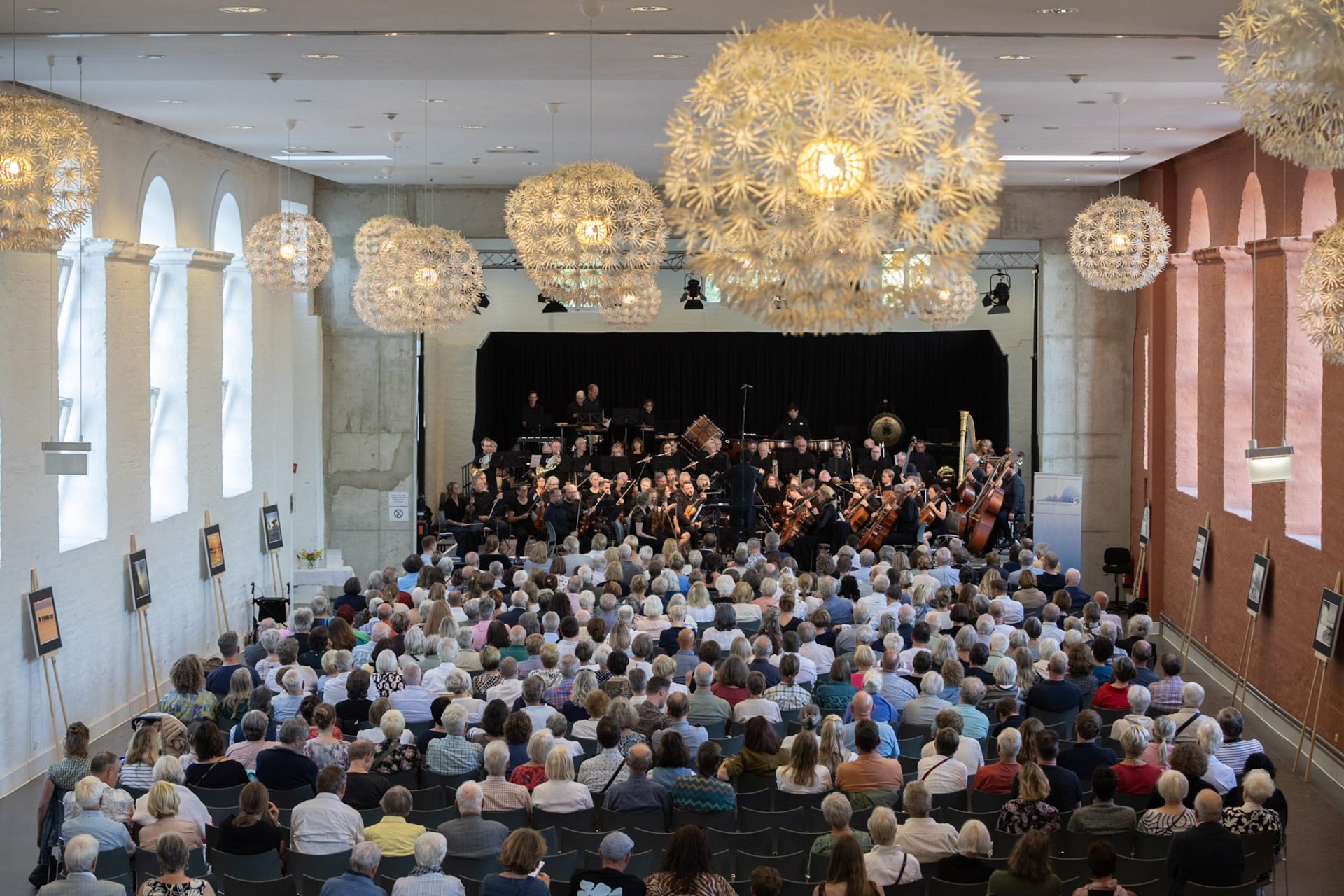 Voll besetztes Publikum und Orchester auf der Bühne im im Marstall Putbus
